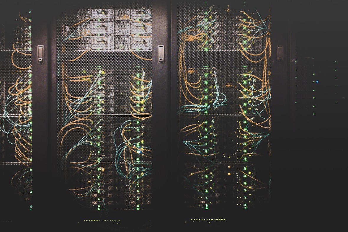 Server racks with patch cables and status lights, the Rusty Telescope cover image.